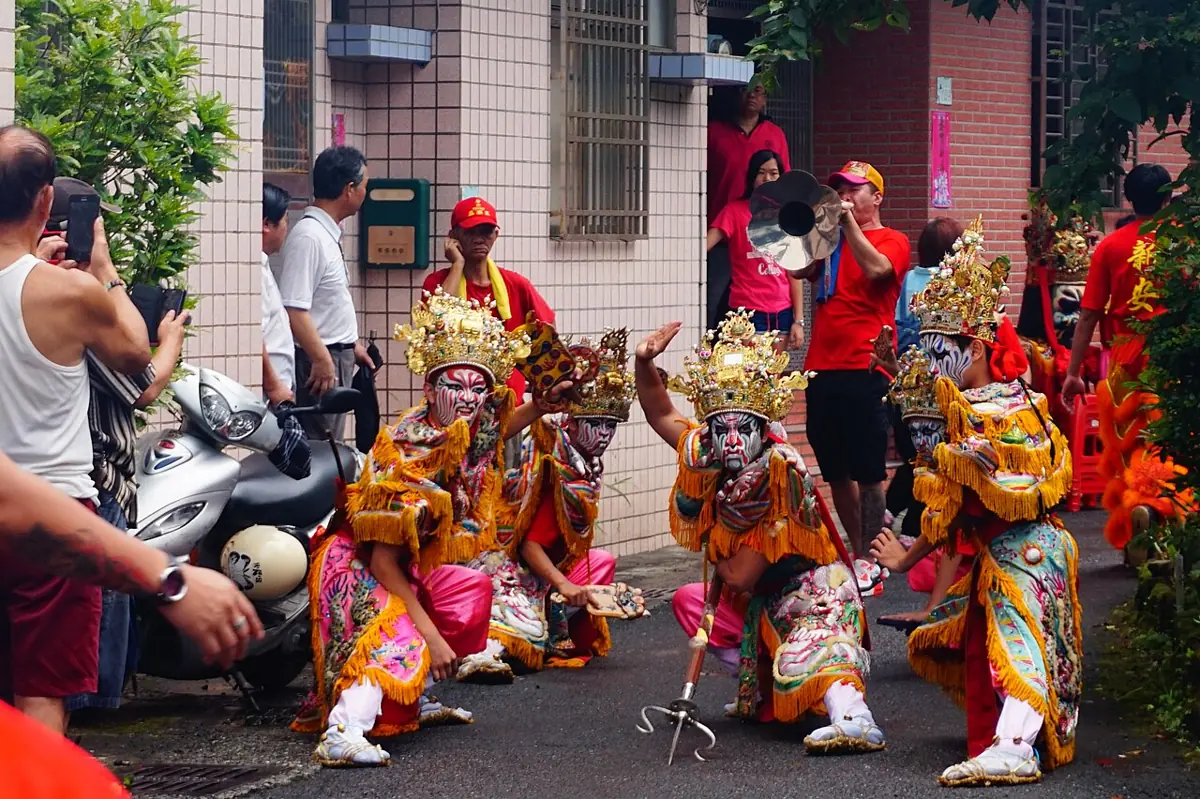 畫上臉譜、身穿彩衣的八家將成員在街頭